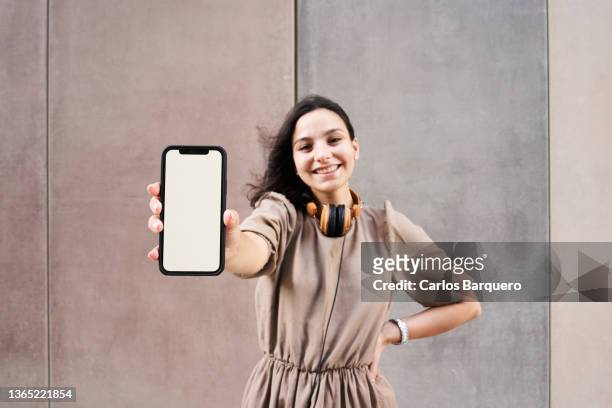 beautiful caucasian young woman showing her phone. - demonstration photos et images de collection