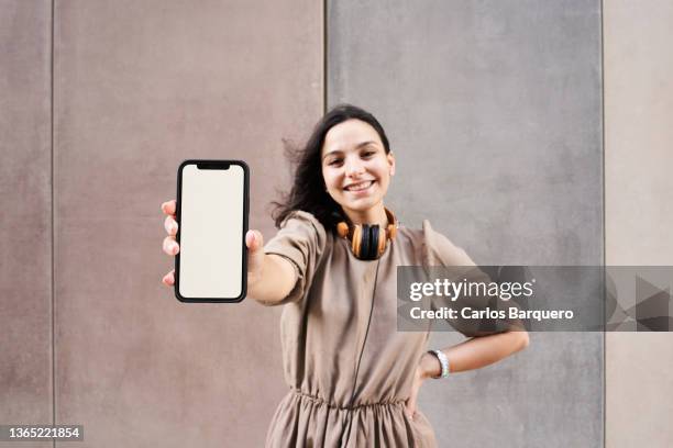beautiful caucasian young woman showing her phone. - tonen stockfoto's en -beelden
