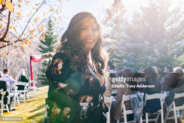 young woman standing with group of seated wedding guests - wedding guest stock-fotos und bilder