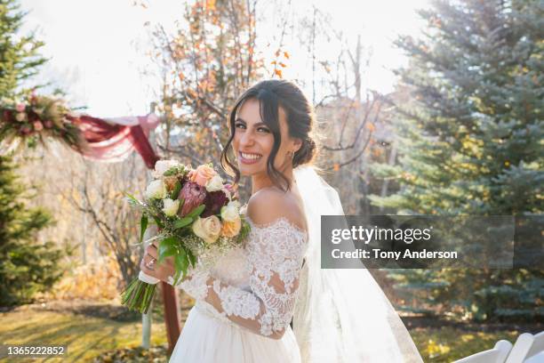 bride posing with bouquet at wedding - noiva imagens e fotografias de stock