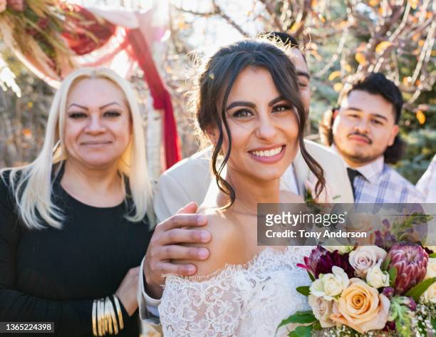 bride and groom with wedding guests at outdoor wedding ceremony - bride holding bouquet stock pictures, royalty-free photos & images