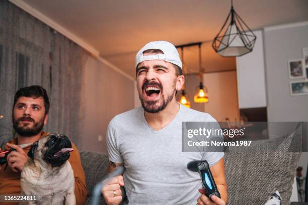 excited friends playing video games - car racing game stock pictures, royalty-free photos & images