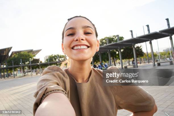 cheerful portrait of a caucasian lady taking a selfie outdoors. - photo messaging fotografías e imágenes de stock