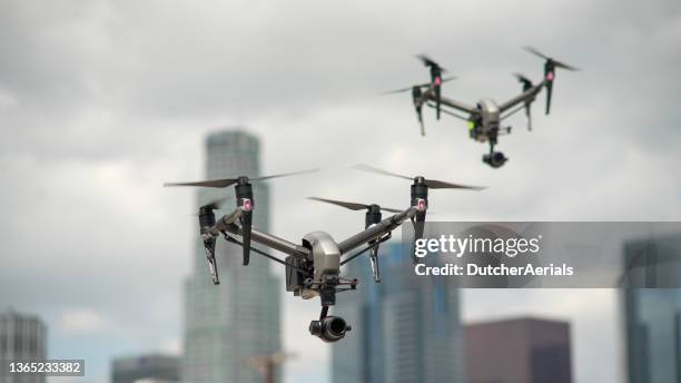 drones flying in a city - quadcopter stock pictures, royalty-free photos & images