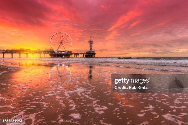 beautiful red sunset on scheveningen beach - la haye stock pictures, royalty-free photos & images