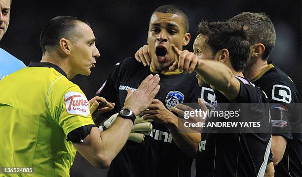 Oldham Athletic's English midfielder Tom Adeyemi reacts next to the referee Neil Swarbrick after hearing a supporter shouting towards him during the...