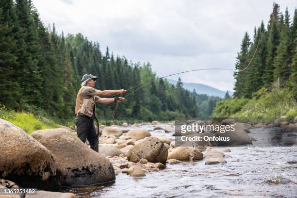 ケベック州の川でシニアマンフライフィッシング - 釣り竿 ストックフォトと画像