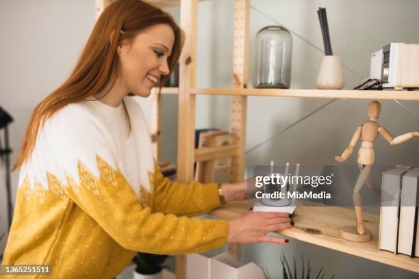 happy young woman sets up a surveillance camera for her apartment - övervakningskamera bildbanksfoton och bilder