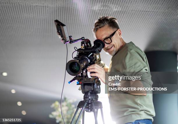 close up of cameraman filming in restaurant - film crew stock pictures, royalty-free photos & images