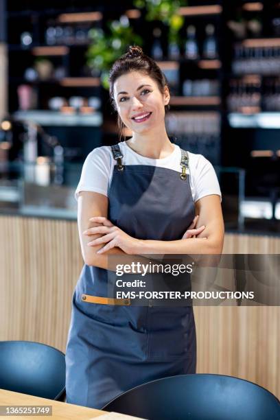 cheerful and smiling business owner standing in her restaurant - chef cook stock-fotos und bilder