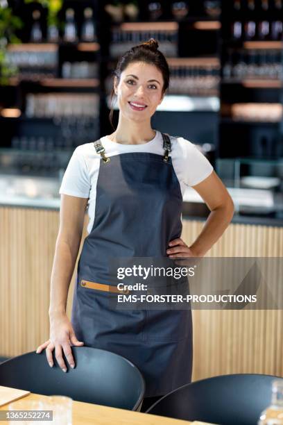 confident and smiling business owner standing in her restaurant - chef cook stock-fotos und bilder