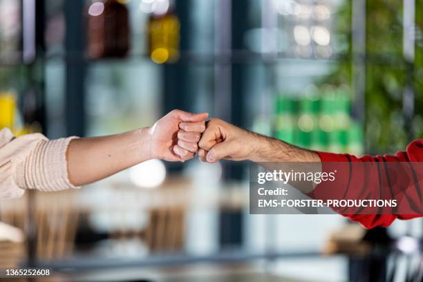 close up from two young friends enjoying alternative greetings - faust stock-fotos und bilder