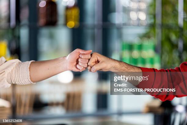 close up from two young friends enjoying alternative greetings - covid handshake stock pictures, royalty-free photos & images