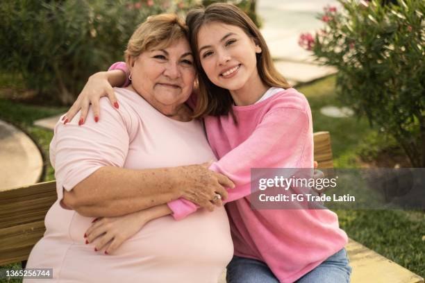 retrato de abuela y nieta abrazadas al aire libre - chubby granny fotografías e imágenes de stock
