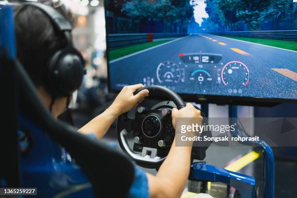 happy boy playingcar racing video game - car racing stock-fotos und bilder