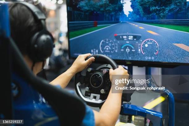 happy boy playingcar racing video game - driver steering wheel stock pictures, royalty-free photos & images