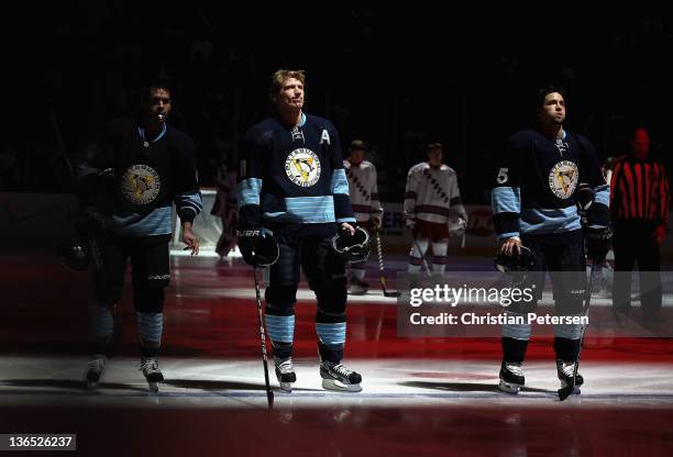 Pascal Dupuis, Jordan Staal and Deryk Engelland of the Pittsburgh Penguins stand attended for the National Anthem before the NHL game against the New...