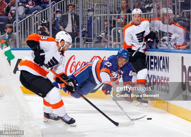 Anders Lee of the New York Islanders is tripped up as he goes up against Ivan Provorov and Justin Braun of the Philadelphia Flyers during the second...