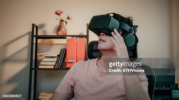 man using virtual reality goggle headset travel on metaverse digital cyber world at home - smartphone hologram stockfoto's en -beelden