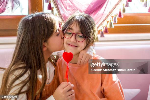 beautiful girls holding a heart-shaped figure - build presents the family stock pictures, royalty-free photos & images