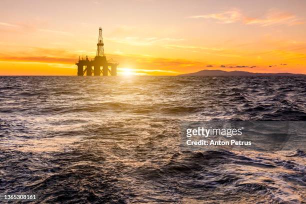 oil platform at sea at sunset. world oil industry - azerbaijan stock-fotos und bilder