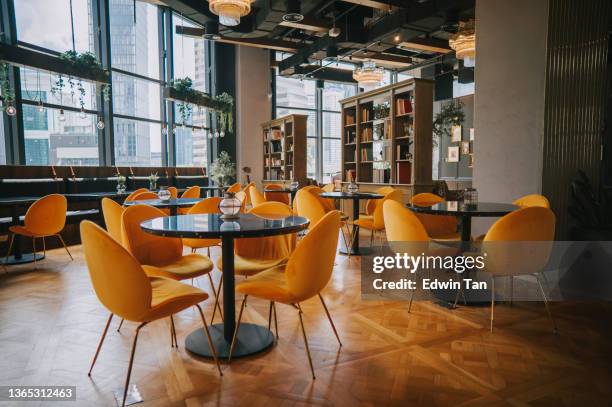 modern cafe restaurant interior with yellow chair against window with city view - coffeeshop stock pictures, royalty-free photos & images