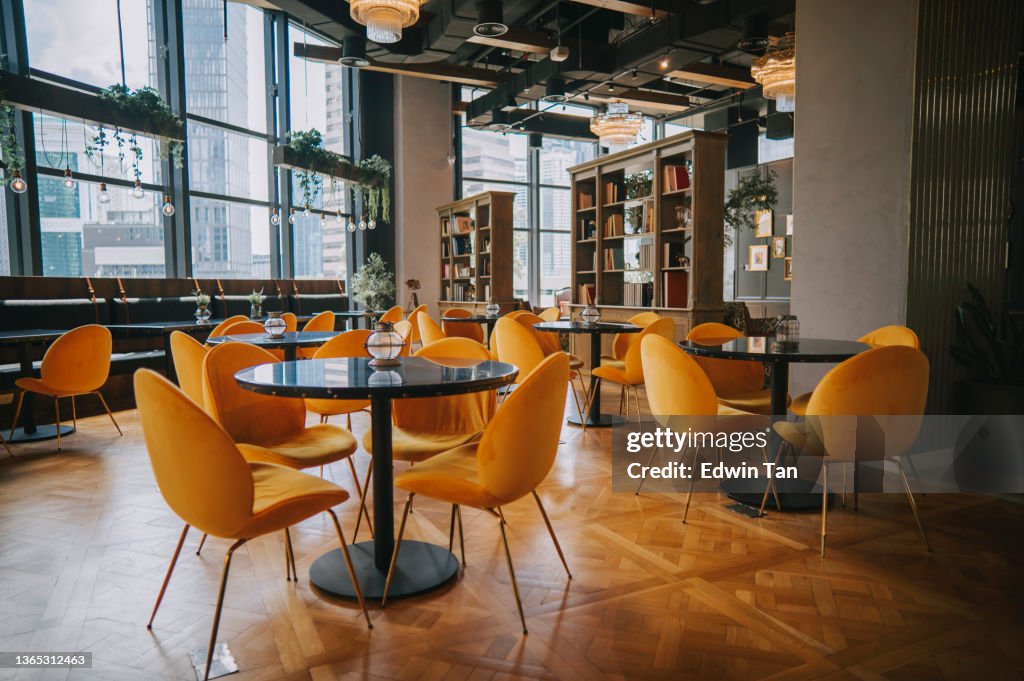Modern Cafe restaurant interior with yellow chair against window with city view