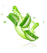 Green gel flowing with aloe vera slices isolated on white background
