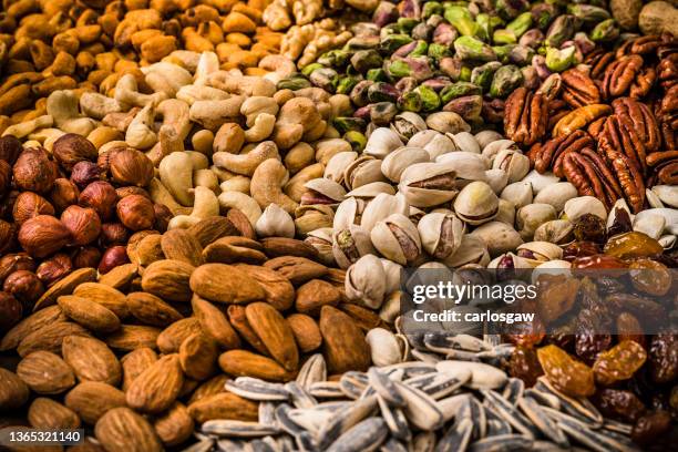 food background: scattered nuts assortment background - pecan nut stock pictures, royalty-free photos & images