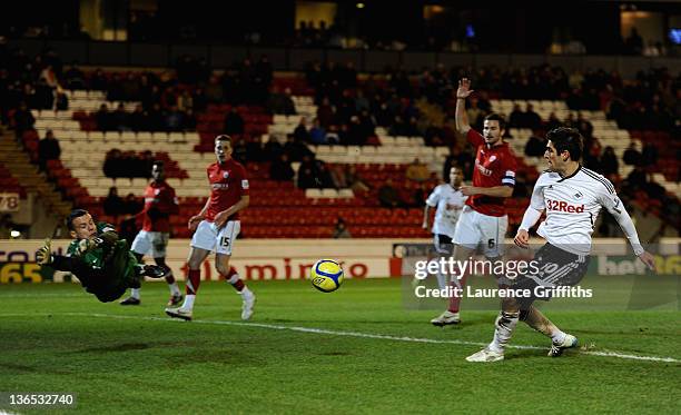 Danny Graham of Swansea scores the third past a diving Luke Steele of Barnsley during the FA Cup Third Round match sponsored by Budweiser between...