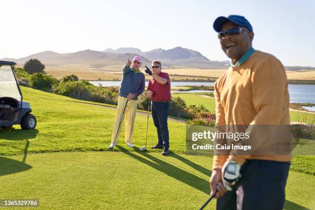 male golfers talking on sunny golf course - senior men golf stock pictures, royalty-free photos & images