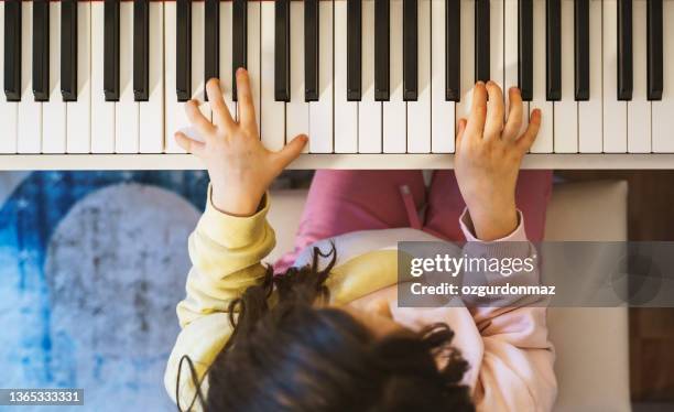 cute little girl playing piano at home - practicing piano stock pictures, royalty-free photos & images