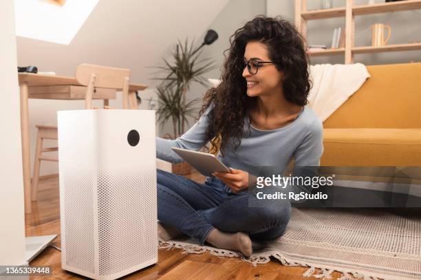 retrato de uma jovem usando um sistema inteligente em sua casa - humidifier - fotografias e filmes do acervo