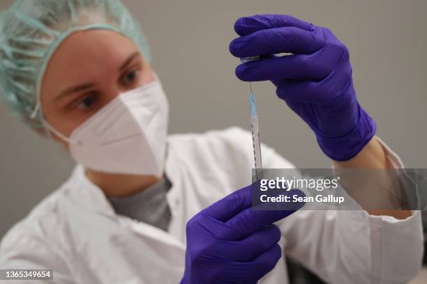 Medical assistant prepares syringes with the Pfizer/BioNTech vaccine against Covid-19 at the Humboldt Forum museum during the Omicron wave of the...