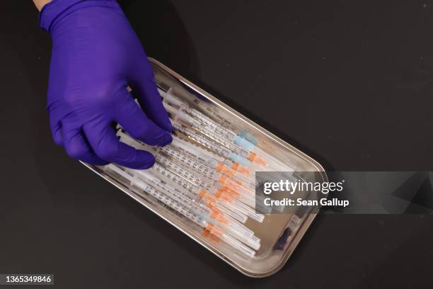 Medical assistant prepares syringes with the Pfizer/BioNTech vaccine against Covid-19 at the Humboldt Forum museum during the Omicron wave of the...