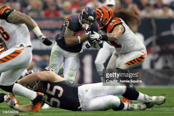 Running back Arian Foster of the Houston Texans runs the ball against Domata Peko of the Cincinnati Bengals during their 2012 AFC Wild Card Playoff...