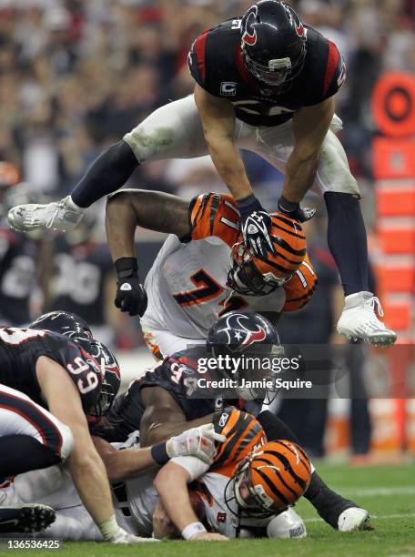 Watt, Antonio Smith and Brian Cushing of the Houston Texans pile on Andy Dalton of the Cincinnati Bengals on a defensive sack during their 2012 AFC...