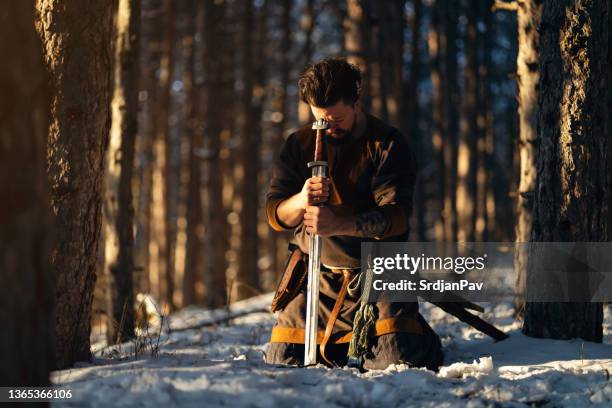 midevial warrior praying in the forest while kneeling - kneeling stock pictures, royalty-free photos & images
