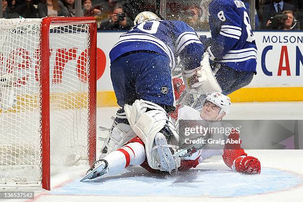 Jiri Hudler of the Detroit Red Wings collides with Jonas Gustavsson of the Toronto Maple Leafs during NHL game action January 7, 2012 at Air Canada...