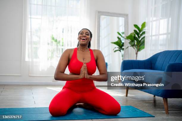 happy woman doing yoga - lotuspositie stockfoto's en -beelden