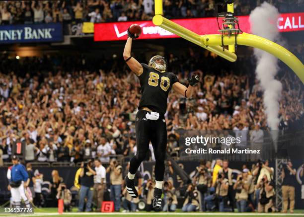 Jimmy Graham of the New Orleans Saints celebrates by dunking the football over the crossbar after scoring a touchdown in the third quarter against...