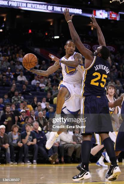 Monta Ellis of the Golden State Warriors looks to pass around Al Jefferson of the Utah Jazz at Oracle Arena on January 7, 2012 in Oakland,...