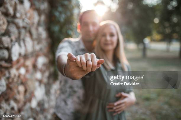 close-up of engagement ring. loving couple is blurred in the background - fiancé stock pictures, royalty-free photos & images