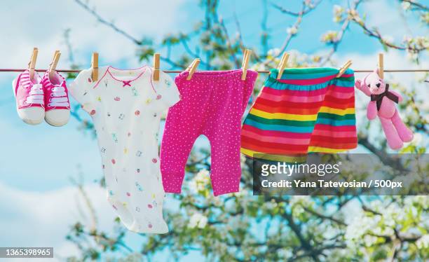 baby clothes are drying on the street selective focus - baby clothing stock pictures, royalty-free photos & images