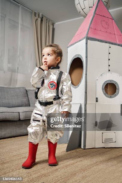 little astronaut thinking how to travel to the stars - spaceman stock pictures, royalty-free photos & images