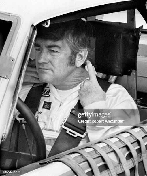 Driver Bobby Allison sits in his race car prior to the start of the 1982 Firecracker 400 stock car race at Daytona International Speedway in Daytona...