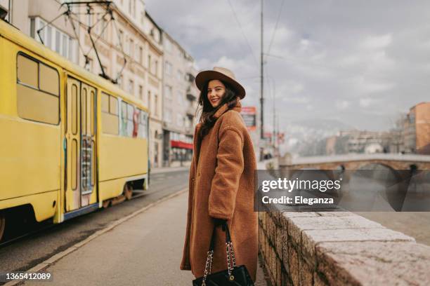 una giovane donna sorridente nel quartiere del centro - cappotto invernale foto e immagini stock