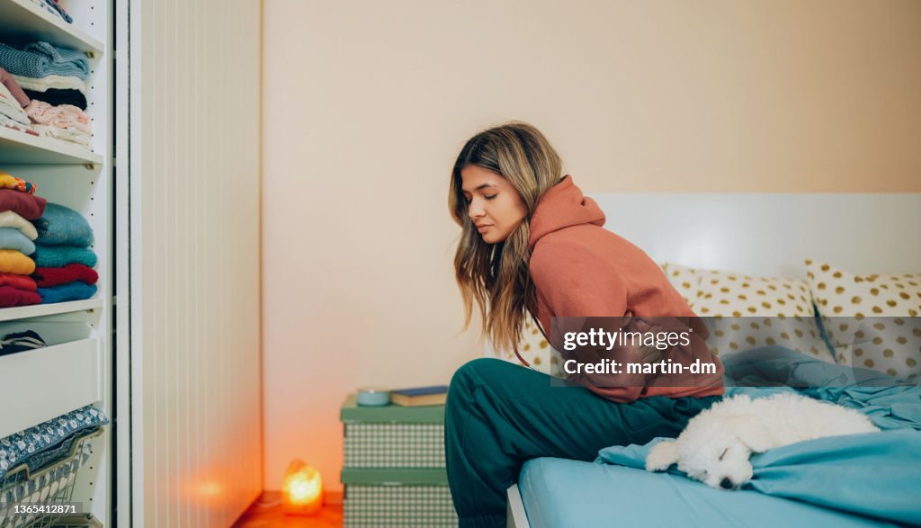 Woman with stomach pain staying home