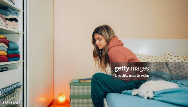 woman with stomach pain staying home - appendicitis imagens e fotografias de stock