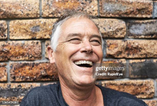 joyful handsome man in his 50s smiling and laughing happily - man open mouth stock pictures, royalty-free photos & images